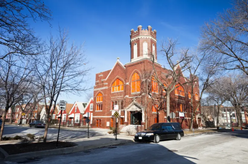 a large red brick building with a hearse in front